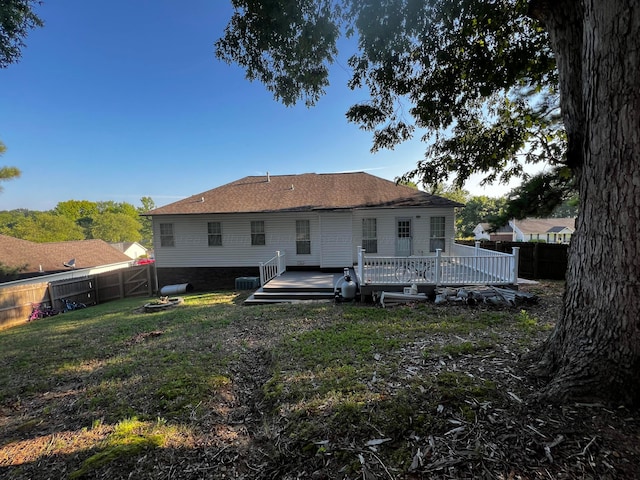 rear view of property with a lawn and a deck