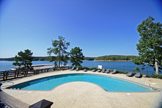 view of swimming pool featuring a patio area and a water view