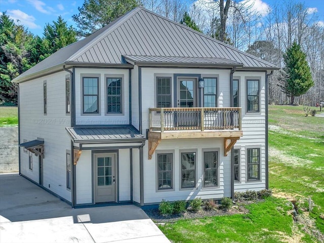 rear view of house with a yard and a balcony