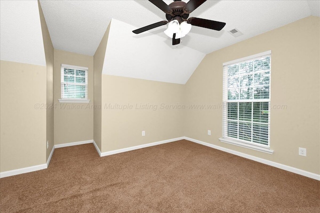 bonus room featuring a textured ceiling, vaulted ceiling, plenty of natural light, and ceiling fan