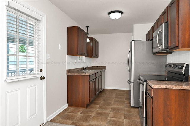 kitchen featuring pendant lighting, sink, appliances with stainless steel finishes, and tasteful backsplash