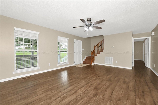 unfurnished living room featuring a textured ceiling, dark hardwood / wood-style floors, and ceiling fan