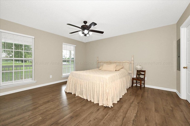 bedroom with ceiling fan, dark hardwood / wood-style flooring, and a textured ceiling