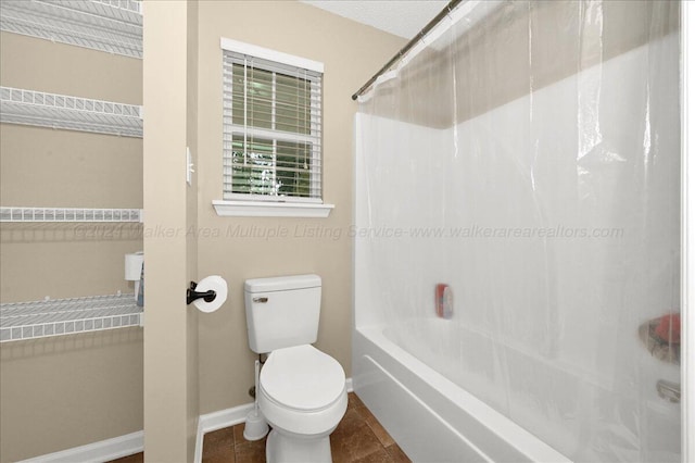 bathroom featuring tile patterned floors, washtub / shower combination, and toilet