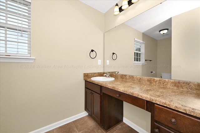 bathroom featuring tile patterned floors, vanity, toilet, and a textured ceiling