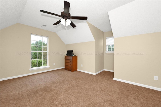 bonus room with a textured ceiling, carpet floors, vaulted ceiling, and ceiling fan