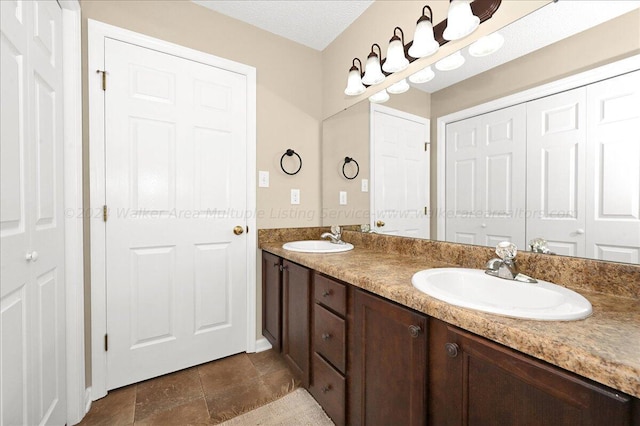 bathroom featuring tile patterned flooring, vanity, and a textured ceiling