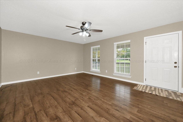 interior space with a textured ceiling, ceiling fan, and dark wood-type flooring