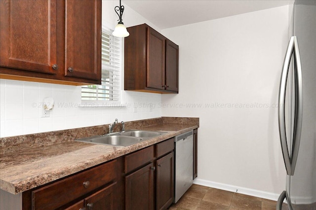 kitchen featuring tasteful backsplash, sink, stainless steel appliances, and decorative light fixtures