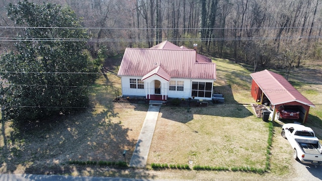 view of front of property featuring metal roof and a front yard