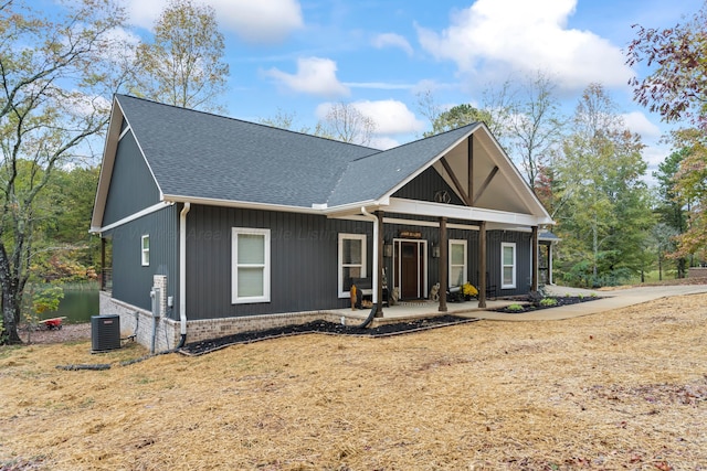 view of front facade with a front yard, central AC, and covered porch