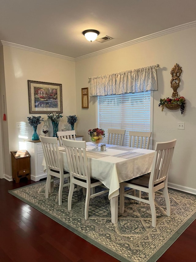 dining room featuring dark wood-style flooring and crown molding