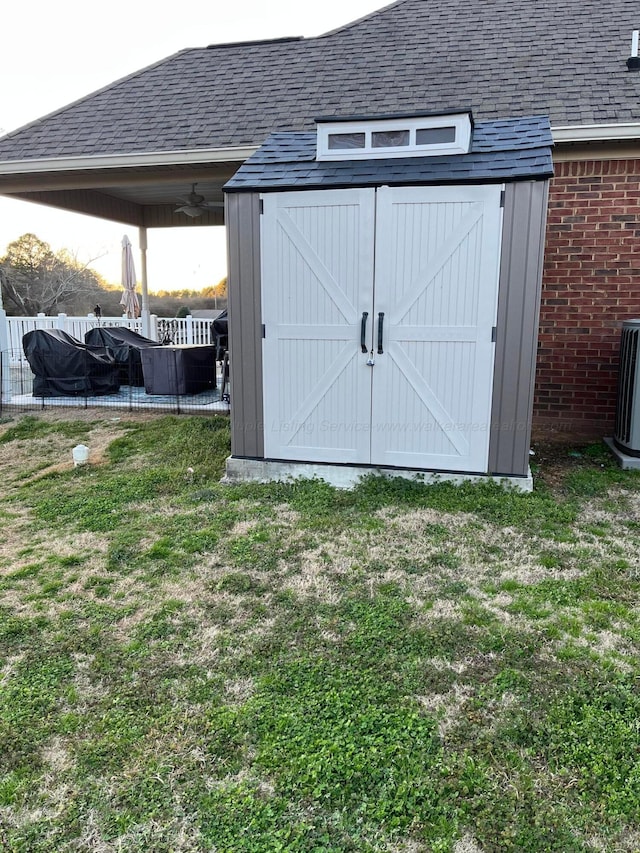 view of shed with central air condition unit and fence