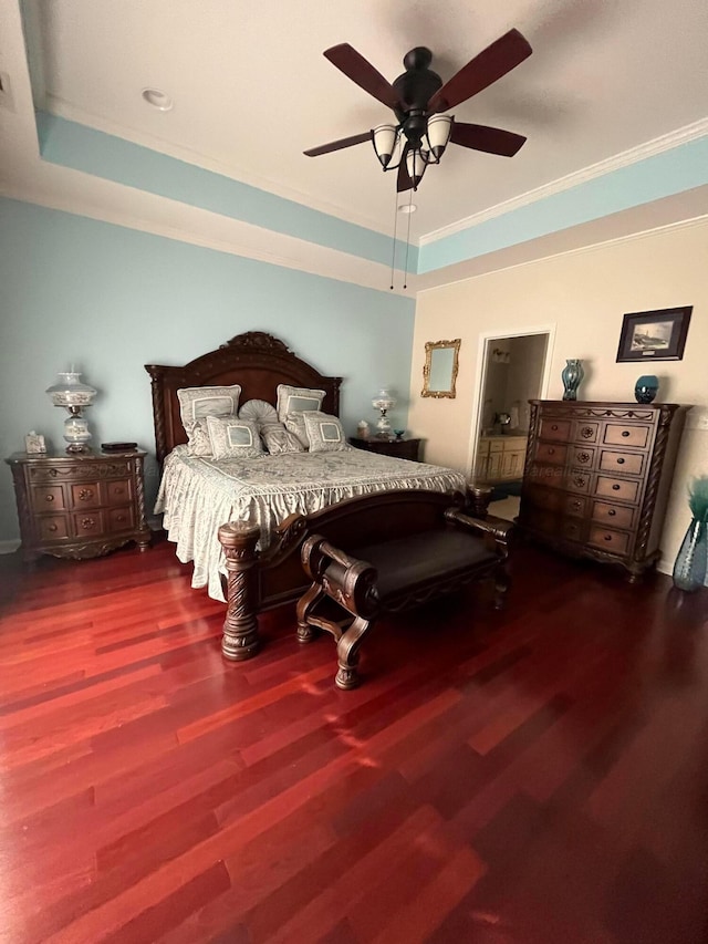 bedroom with ceiling fan, crown molding, a tray ceiling, and wood finished floors