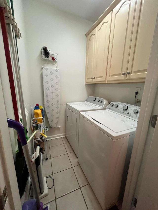 washroom featuring cabinet space, baseboards, separate washer and dryer, and light tile patterned flooring