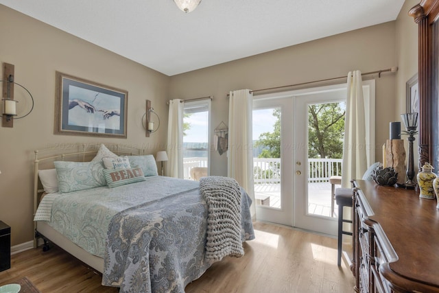 bedroom with light hardwood / wood-style floors, access to outside, and french doors