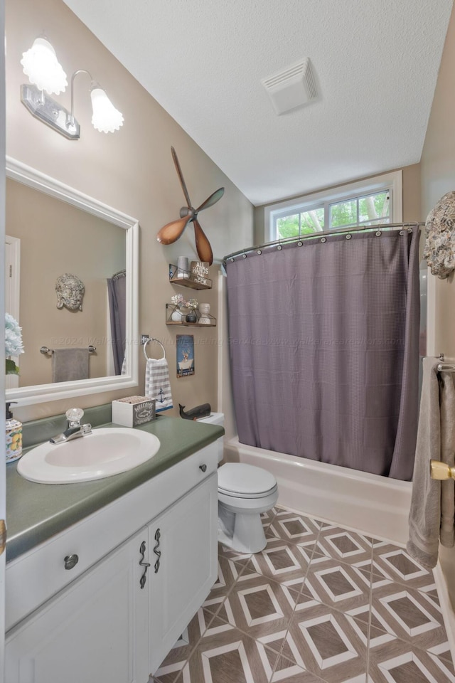 full bathroom featuring vanity, toilet, shower / bath combo with shower curtain, and a textured ceiling