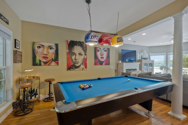 rec room with a textured ceiling, hardwood / wood-style flooring, ceiling fan, and billiards