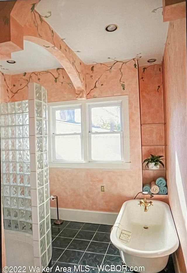 bathroom featuring tile patterned floors and a tub to relax in