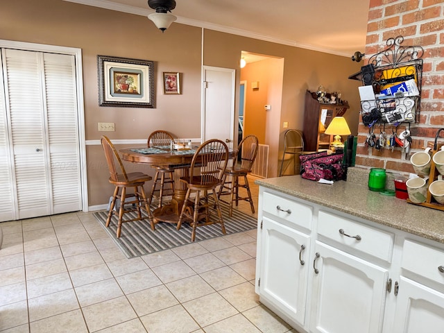 dining space with light tile patterned floors and ornamental molding