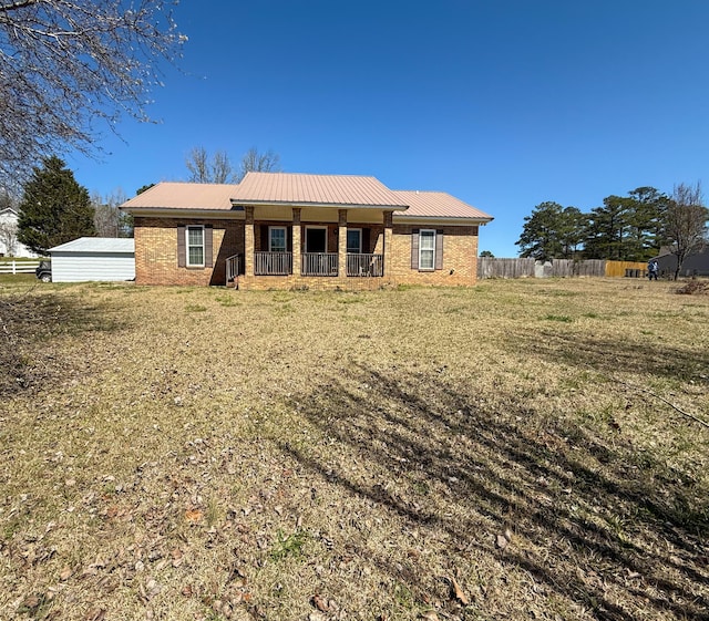 view of front of property with brick siding, covered porch, metal roof, and fence