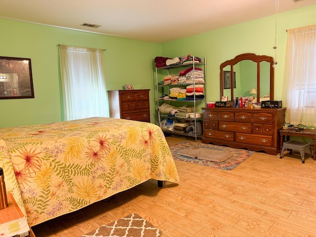 bedroom with wood finished floors and visible vents