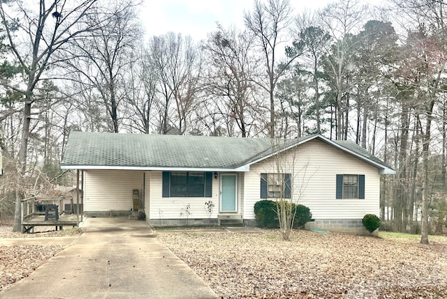 ranch-style home featuring entry steps, driveway, an attached carport, and roof with shingles