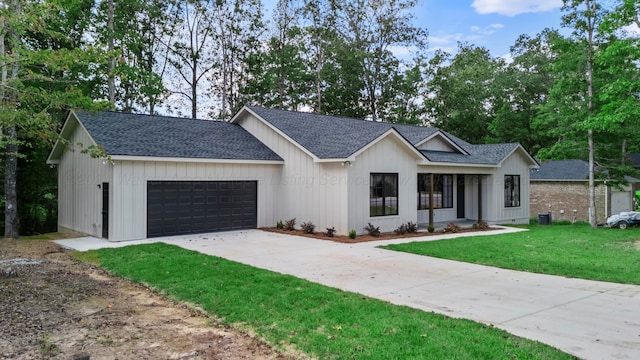 modern farmhouse featuring a garage and a front lawn