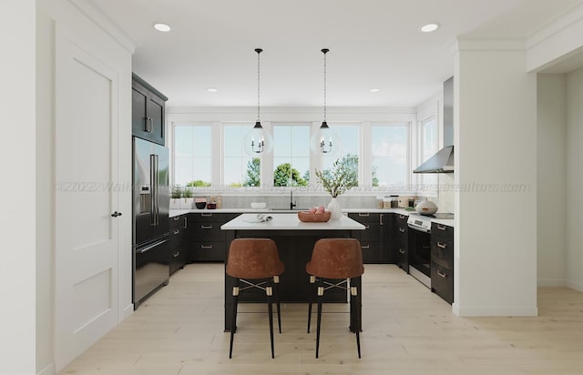 kitchen with a center island, wall chimney range hood, a breakfast bar area, high end fridge, and light wood-type flooring