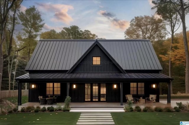 back house at dusk featuring a patio