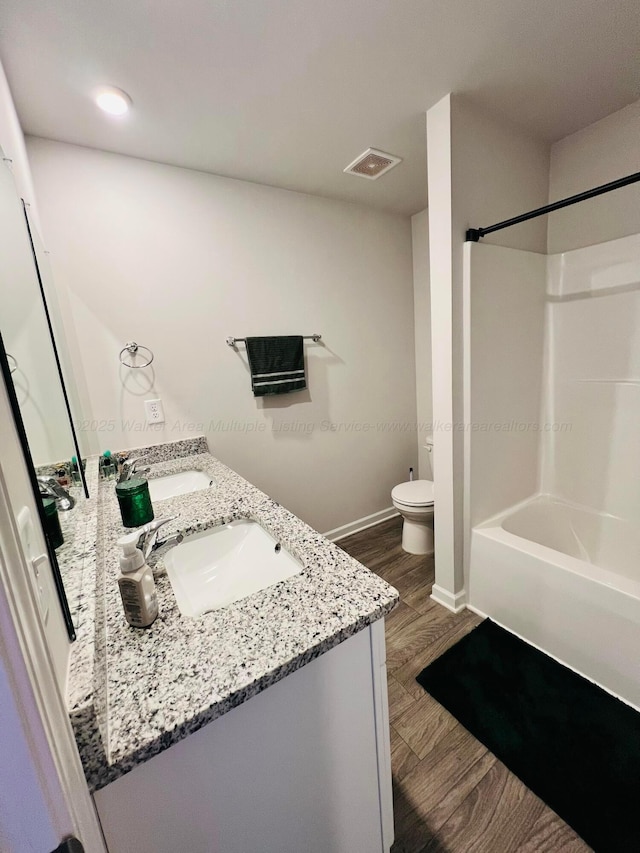 full bathroom with toilet, vanity, shower / tub combination, and hardwood / wood-style floors