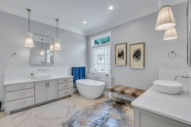 bathroom with a tub, vanity, and ornamental molding