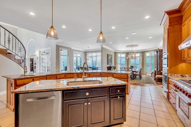 kitchen with a kitchen island with sink, sink, ornamental molding, appliances with stainless steel finishes, and plenty of natural light