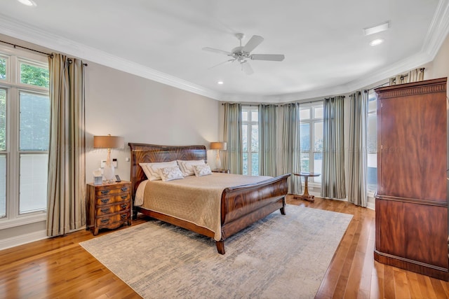 bedroom featuring light wood-type flooring, ceiling fan, and crown molding