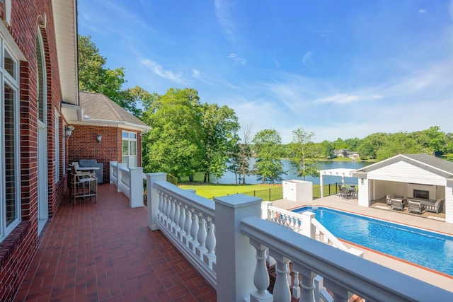 view of pool with a yard, an outbuilding, and a water view