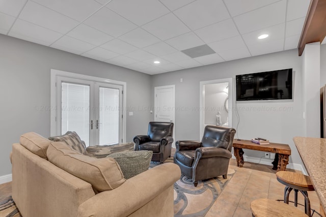 tiled living room featuring a paneled ceiling and french doors