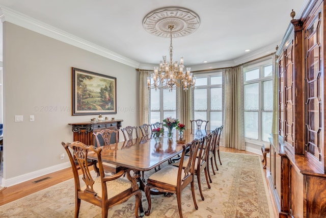 dining area featuring crown molding, a notable chandelier, and light wood-type flooring