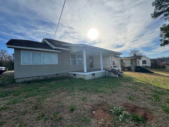 view of side of property featuring a porch and a yard