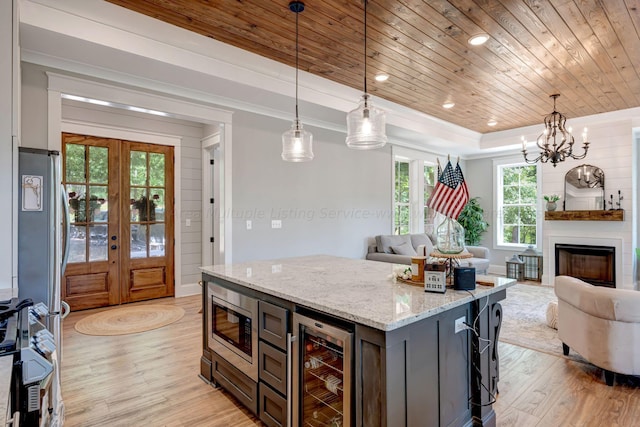 kitchen featuring wood ceiling, beverage cooler, stainless steel appliances, and open floor plan