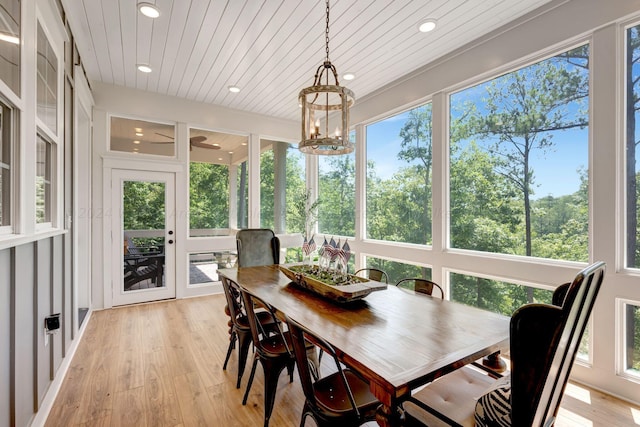 sunroom / solarium with a chandelier, wood ceiling, and plenty of natural light