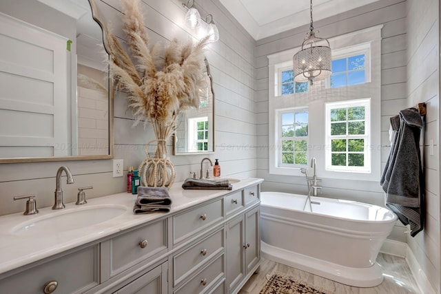 bathroom with double vanity, a freestanding tub, and a sink