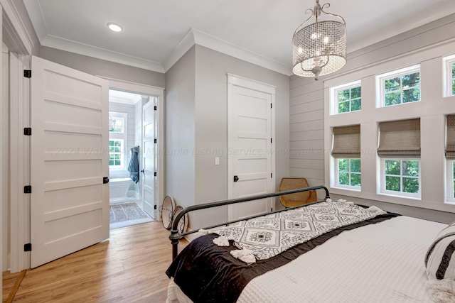 bedroom with ornamental molding, light wood-type flooring, and multiple windows