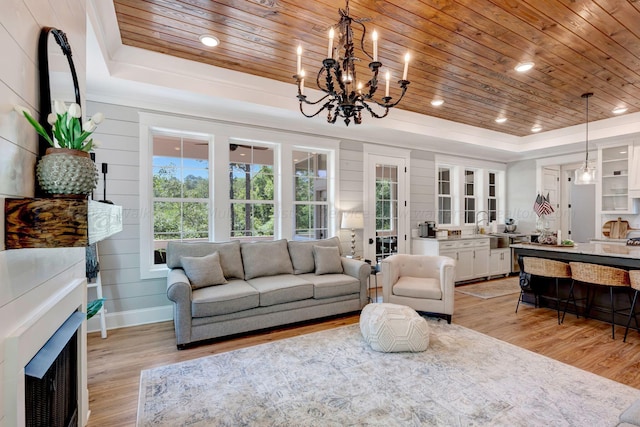 living room with wooden ceiling, a raised ceiling, and light wood-style flooring