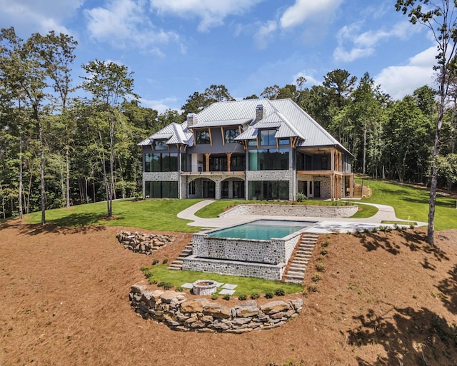 back of house with a balcony and a lawn