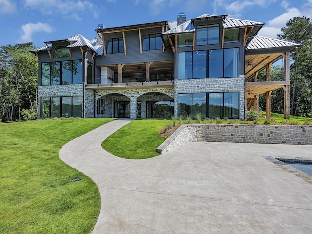 rear view of house featuring a lawn and ceiling fan