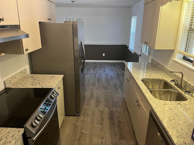 kitchen with a sink, under cabinet range hood, dark wood-style floors, white cabinetry, and stainless steel appliances