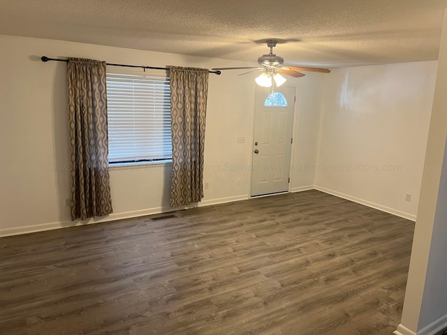 entryway with baseboards, dark wood-type flooring, and a textured ceiling