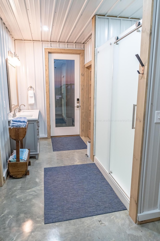 bathroom with concrete floors, walk in shower, and vanity