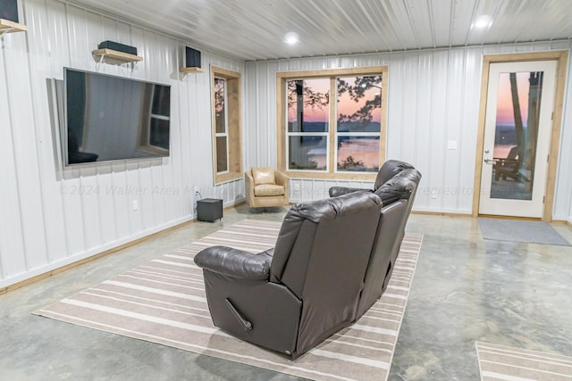 living room featuring concrete floors and wooden walls