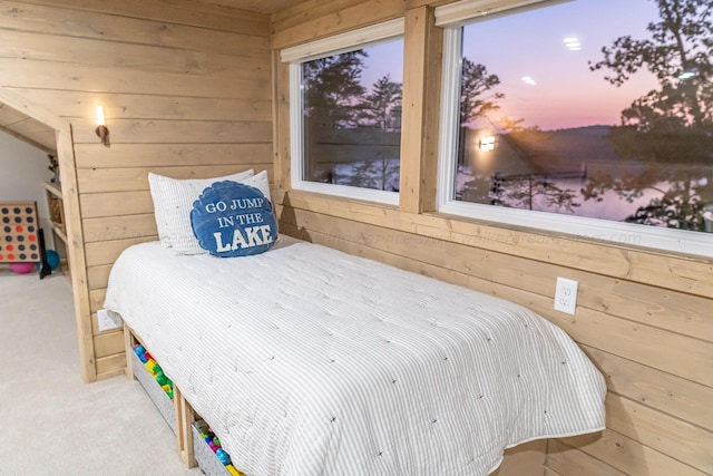 carpeted bedroom featuring wooden walls